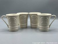 Set of four cream-colored fine china mugs with embossed shamrock design displayed side by side