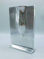 Front and side views of the polished metal vase showing sculpted organic female form and overall shape including flat base.