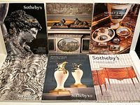 Front covers of six Sothebys Paris auction catalogues displayed showing various artistic themes and auction subjects.