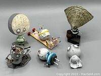 Six vinyl figures from the Tim Burton's Tragic Toys series displayed together, some with visible damage and broken parts.