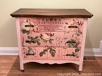 Front view of the dresser showing all three drawers and painted floral motif