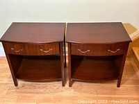 Pair of vintage mahogany wood side tables shown side by side, front view focusing on drawers and shelf below.
