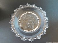 Top view of clear textured glass dish showing beaded scalloped edge and central etched design.