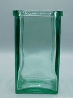 Front view of vintage Spanish square glass vase showing green tint and smooth surface