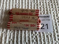 Three rolls of 1943 steel pennies, each wrapped in brown paper with red imprints and handwritten '1943 Steel' on the wrapper.