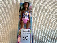 Full shot of new Barbie doll in clear plastic packaging with butterfly floral swimsuit
