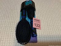 Photo showing two CONAIR Salon Results hair brushes still attached to original packaging, featuring one large cushioned paddle brush and one smaller detangling brush in black and blue colors with ball-tipped bristles.