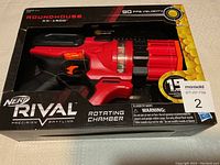 Photo of the front of the Nerf Rival Roundhouse XX-1500 blaster box showing the blaster inside and highlighting key features such as 90 FPS velocity, rotating chamber, and 15 round capacity.