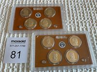 Two plastic cases with four U.S. Presidential dollar coins each, arranged on an orange background with the U.S. Treasury seal, placed on a white textured surface.