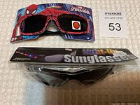 Photo showing the Spider-Man sunglasses on branded packaging and separate packaged light-up sunglasses.