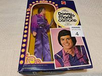 Front view of the Donny Osmond doll in original box with signed photo card