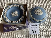 Photo showing both Wedgwood jasperware pieces on a light textured surface alongside the original Wedgwood box.