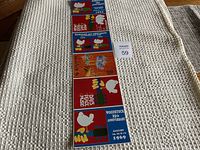 Six Woodstock 25th Anniversary postcards laid out in a vertical line on a textured white fabric surface.