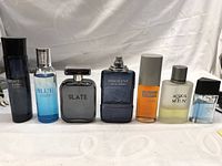 Front view of the 7 perfume bottles displayed in a row showing variety of bottles and labels.