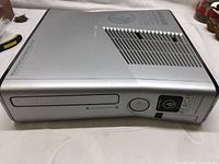 Side view of silver Xbox 360 Heather Reach Limited Edition console showing disc drive and ventilation.