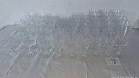 Wide-angle photo of the full set of clear crystal glasses with multiple sizes in same cut pattern.