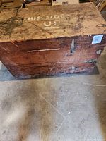 Front and top view showing worn wooden surface, metal latch, and 'THIS SIDE UP' stencil