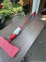 Full view of Vileda microfiber spray mop lying on table showing mop head and integrated spray bottle