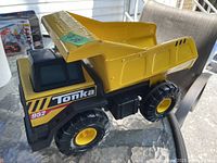 Side view of the Tonka dump truck showing 'Tonka' decal and yellow dump bed.