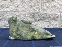 Side view of the green stone seal sculpture showing the full body and flipper details.