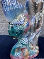 Close-up side view of ceramic tropical fish figurine with detailed scales and fins in colorful glaze.