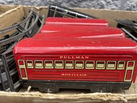 Close-up of red Pullman Montclair passenger cars showing window and lettering details with some paint wear.
