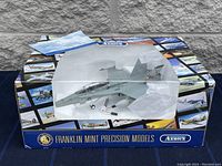 Die-cast model aircraft in original box with clear plastic window showing detailed jet with landing gear down and painted gray.