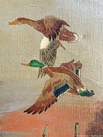 Close-up of painted ducks mid-flight showing details of feathers and colors on canvas.