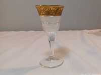 Full view of Moser Splendid 24K gold-banded liqueur glass with detailed cut crystal and ornate gold rim pattern