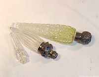 Three bottles on table showing caps and crystal bodies