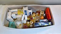Top-down view of multiple sample fragrance bottles and boxes neatly packed in a white box.
