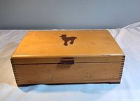 Closed wooden hinged box with poodle silhouette on lid