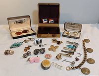 Full lot overview showing all cuff links, tie clips, military button bracelet and case