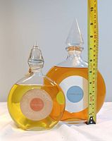 Two Flacon Montre bottles side by side with measuring tape showing height