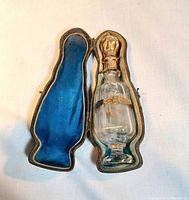 Glass perfume bottle seated in custom velvet-lined case showing fitted interior