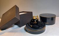 Outer rectangular box removed lid showing round black box, atomizer bottle and bulb pump