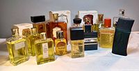 Overview of 13 assorted large fragrance bottles on white cloth