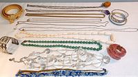Full lot arranged flat on white background showing belt, chains, beads and bracelets