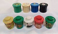Overview of all 10 Molinard Concreta flower pot-shaped perfume pots in various colors and hand-painted designs