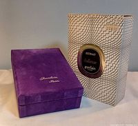 Closed purple velvet box beside original retail box