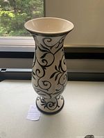 Black and white vase with swirling patterns on a white background