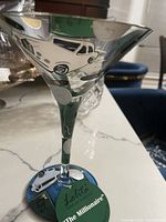 Clear martini glass with vintage car hand painted designs. Label on base with Lolita branding and 'The Millionaire' name.