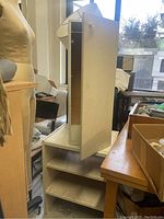 Front of white cabinet and side table set showing cabinet door open and side table with open shelves