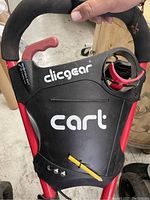 Close-up photo of the handle and the front panel marked with 'clicgear cart' and a cup holder.