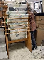 Full view of wooden scroll holder supporting six decorative printed scrolls with floral and bird designs.