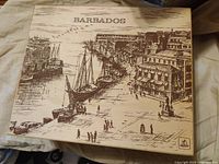 Closed box featuring sepia-toned illustration of Barbados harbor front and the word Barbados on lid