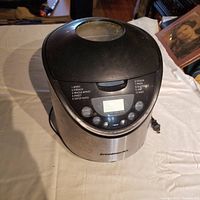 Top and front view of the Breadman Pro breadmaker showing control panel with menu options and display screen