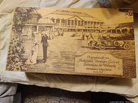 Top of wooden box with vintage etched scene and Henkell branding information in German.