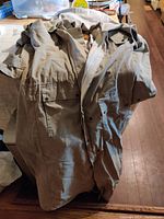 Full view of the khaki long duster coat with pockets and button details.