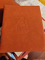 Brown embossed binder cover with Canada coat of arms, marked 'CANADA'